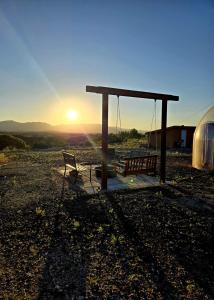 a picnic shelter with two benches and the sunset at Stargazing Retreats Homestay in Camp Verde