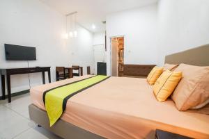 een slaapkamer met een groot bed en een bureau bij The Panorama Suites by MHM in Jakarta