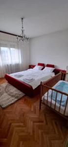 a bedroom with a large bed and a chandelier at Modern Spacious ViS Raska Apartment! 5min Cafes in Raška