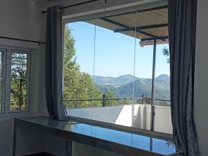 een kamer met een groot raam en een bad bij Cherry Blossom in Kotagiri