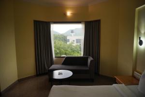 a room with a couch and a chair and a window at Darling Residency in Vellore +29 photos