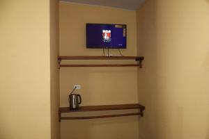 a room with a tv on a wall at habitacion costabay in San Luis La Herradura