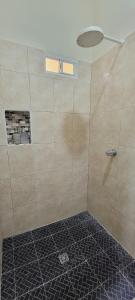 a bathroom with a shower with a tiled floor at habitacion costabay in San Luis La Herradura