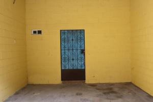 a yellow room with a door in the corner at habitacion costabay in San Luis La Herradura