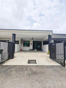 a white house with a gate and a driveway at Inap Indah in Kuantan