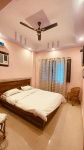 Un dormitorio con una cama grande con ventilador de techo. en Aradhya Gange Residency, en Rishīkesh
