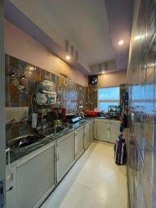 Una cocina con gabinetes blancos y un fregadero grande. en Aradhya Gange Residency, en Rishīkesh