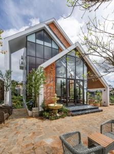 a house with large windows and a patio at Là Yên Retreat in Ấp Ða Lợi
