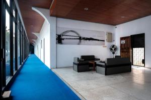 a hallway with a blue carpet in a building at RedDoorz at Cempaka Putih Jambi in Jambi +9 photos