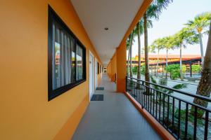 Un pasillo de un edificio con palmeras. en นงนุช บูติค รีสอร์ท, en Na Jomtien