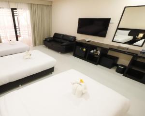 ナ・ジョムティエンにあるนงนุช บูติค รีสอร์ทのリビングルーム(ベッド2台、テレビ付)
