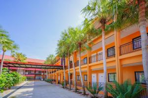 ナ・ジョムティエンにあるนงนุช บูติค รีสอร์ทの建物前のヤシの並木