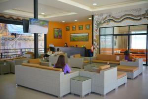 Una sala de espera con gente sentada en sofás. en นงนุช บูติค รีสอร์ท, en Na Jomtien