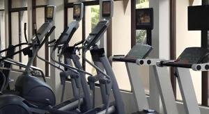 una fila de máquinas de cardio en un gimnasio en Hotel Ruposhi Bangla, en Bāg Noādda