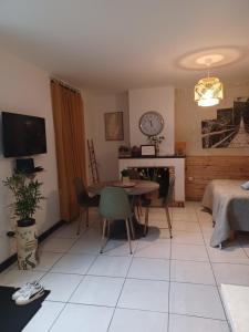 een woonkamer met een tafel en een tv bij Le Refuge in Saint-Aignan