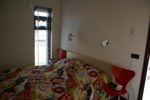 スコールルにあるBergen Holiday Homeのベッドルーム1室(カラフルな掛け布団付きのベッド1台付)
