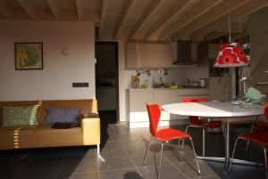 a living room with a couch and a table at Bergen Holiday Home in Schoorl
