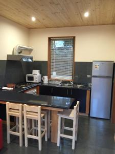 a kitchen with a refrigerator and a table and chairs at Loft Pucon in Pucón