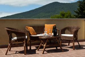 a patio with wicker chairs and a table with wine glasses at B&B Monte Vulture in Rionero in Vulture