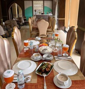 a wooden table with plates of food on it at Hotel Mekkah Banda Aceh in Lamglumpang
