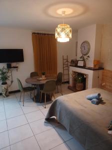 een slaapkamer met een bed, een tafel en een tv bij Le Refuge in Saint-Aignan +5 foto's