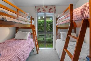 two bunk beds in a room with a window at White Sands Haven - Omaha Family Escape in Omaha