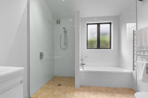 a white bathroom with a tub and a shower at White Sands Haven - Omaha Family Escape in Omaha