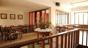 a restaurant with tables and chairs and a potted plant at Mango Valley Hotel in Olongapo
