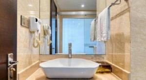 Hangzhou Wangzhou Boutique Hotel في Yuhang: حمام مع حوض ومرآة كبيرة +39 صورة