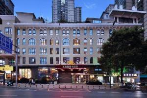 ZIXIN FOUR SEASONS HOTEL في Gutang: مبنى كبير على شارع المدينة به