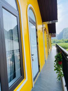 a yellow house with a balcony with a view at Tam Coc Hope House in Ninh Binh