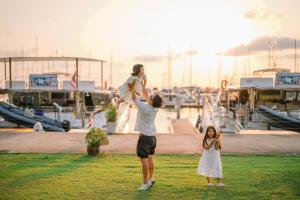 Ein Mann, der ein Kind auf seinen Schultern in einem Jachthafen trägt in der Unterkunft Ocean Marina Resort Pattaya Jomtien in Na Jomtien
