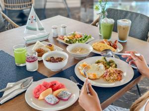 ein Tisch mit Tellern voller Frühstücksspeisen darauf in der Unterkunft Ocean Marina Resort Pattaya Jomtien in Na Jomtien
