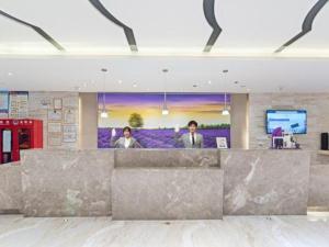 Lavande Hotels Urumqi Xinmin West Street Hongda Plaza في أورومكي: سيدتان واقفتان في مكتب في الردهة