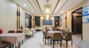 Magnotel Hotel Shanghai Railway Station Magnolia Plaza في شانغهاي: غرفة طعام مع طاولات وكراسي في غرفة
