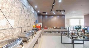 Un restaurante con varias mesas en una sala grande. en James Joyce Coffetel·Changchun Railway Station, en Changchún