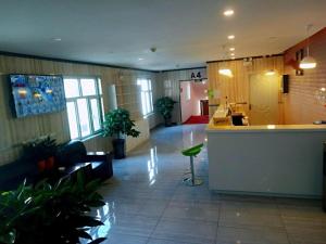 PAI Hotels·Urumqi South Gate Xinhua Bookstore في أورومكي: ردهة مكتب بها بار ونباتات بداخلها