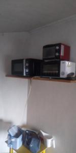two microwaves are sitting on a shelf at raibrasil guest house in Sanuki