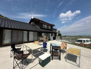 Un patio con sillas y una mesa y una casa. en とっくりhouse, en Takashima