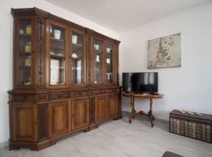 een grote houten kast in een kamer met een tafel bij Appartamenti Ora e Peler in Riva del Garda