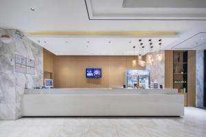 City Comfort Inn Wuhan East Lake Scenic Area Happy Valley في ووهان: ردهة بها مكتب استقبال في مبنى