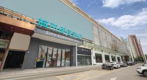 City Comfort Inn Wuhan East Lake Scenic Area Happy Valley في ووهان: مكتبة المدينة مع السيارات متوقفة في موقف السيارات