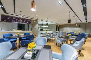 a dining room with blue chairs and tables and tablesktop at Echarm Hotel Nanning Baisha Avenue Tingjiang Interchange BBK in Nanning