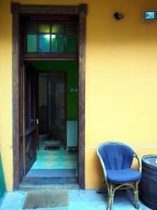 Guest Accommodation Etno Konak Tašana في نيشْ: كرسي ازرق جالس امام مبنى