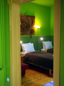 Guest Accommodation Etno Konak Tašana في نيشْ: غرفة خضراء بسريرين ومصباح