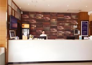 a woman sitting at a counter in a restaurant at JTOUR Inn Huangshi North Station Cihu Scenic Area in Huangshigang