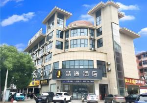 a building with cars parked in front of it at JTOUR Inn Huangshi North Station Cihu Scenic Area in Huangshigang