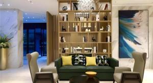 a living room with a green couch and a book shelf at City Comfort Inn Wuhan Wangjiawan Longyangcun Metro Station in Wuhan