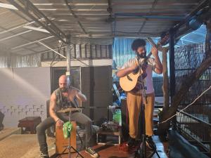 Dos hombres tocando instrumentos y un hombre tocando una guitarra en Lunar Park, en Phumĭ Ta Phŭl
