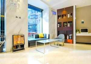 a living room with a couch a table and a tv at City Comfort Inn Guiyang Yan'an Middle Road Fountain Metro Station in Guiyang